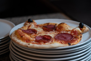 Kinder Margarita Pizza mit Gesicht aus dem Pizzaofen auf einem Teller und in einer Schachtel