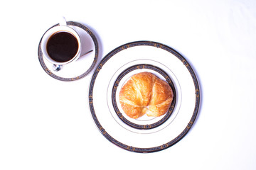 Coffee In A Formal China Cup On A Saucer With Spoon With Croissant On China Plate On A White Background