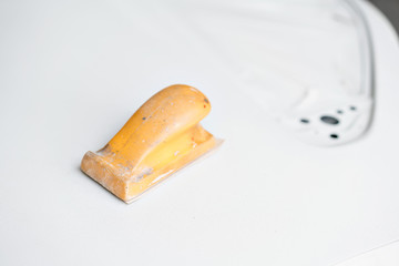 Garage painting car service. door section of the car is covered with primer. Repairing car body work after the accident by working sanding primer before painting.