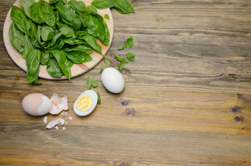 boiled eggs and Basil leaves on wooden background 