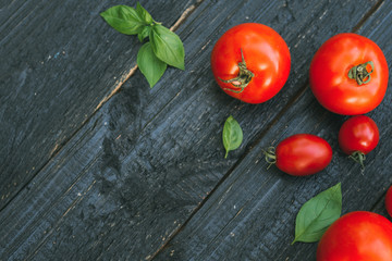Red tomatoes on a wooden black background
