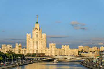 Obraz premium Moskvoretskaya embankment and Kotelnicheskaya embankment Moscow river with stalinist skyscraper 1938-1952 years of construction. Residential Soviet high-rise building. Bolshoy Ustyinsky Bridge.