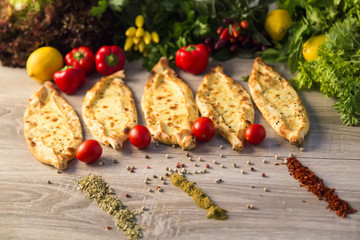Adana Pide and tomato, lemon, lettuce,pepper and green vegetables on the wooden background for restaurant and cafe concept.
