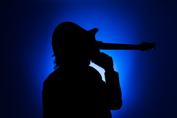 Shadow of a musician carrying a guitar