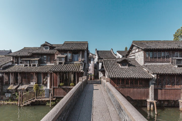 Fototapeta premium Stone Bridge Leading to Chinese Houses