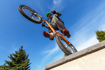 BMX cyclist made tricks on street, pro rider trainong