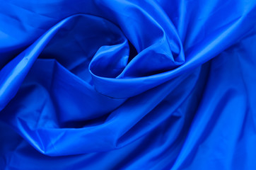 Blue Synthetic Lining Fabric with Folds. Crumpled Sheet or Clothes Background,
