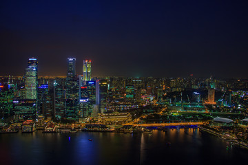 Fototapeta na wymiar SINGAPORE, January 19 2014 - Singapore Skyline at Night viewed from Ku De Ta Restaurant in Marina Bay Sands hotel