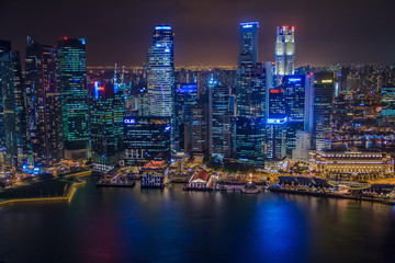 Fototapeta na wymiar Singapore, SINGAPORE, January 19 2014 - Singapore Skyline at Night viewed from Ku De Ta Restaurant in Marina Bay Sands hotel