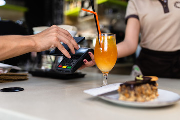 Payment transaction with smartphone in a snack bar.