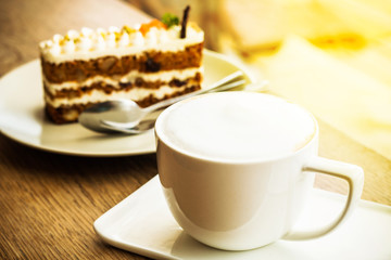 Cake carrot and cup coffee on table wooden in coffee shop