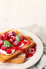 Healthy breakfast with toast and raspberries on wooden table