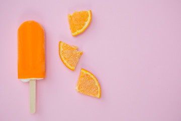 Popsicle with fresh orange on a table