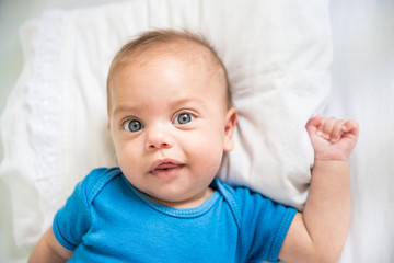 Blue eyed baby boy lying in crib - Lifestyle