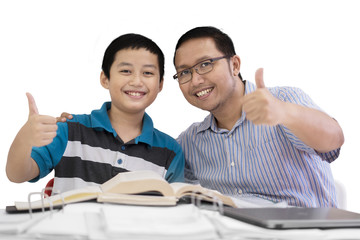 Preteen boy showing thumbs up with his father