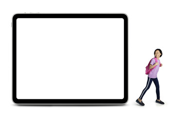 Cheerful schoolgirl looks at a blank whiteboard