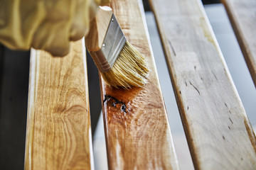 Paint Brush in a can of varnish in preparation to stain the wood slats