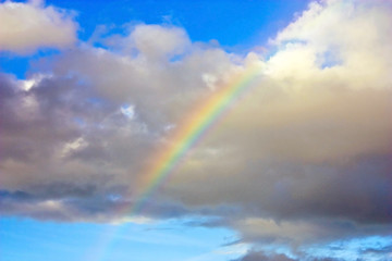 Beautiful rainbow in bright blue sky with cloud after the rain