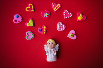Cupid doll and heart-shaped on red background