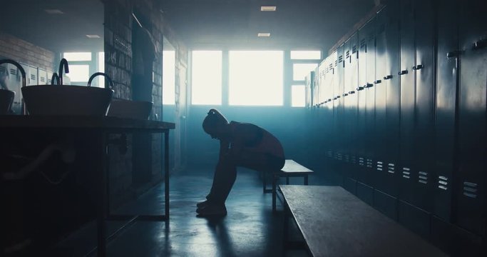DOLLY IN Caucasian female athlete preparing for a workout in a gym locker room, tying shoelaces before training session. 4K UHD 60 FPS SLOW MOTION