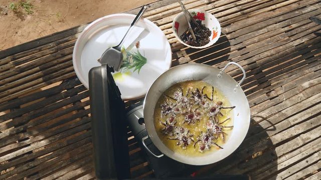 Deep fried tarantulas in wok cooking (upper view)