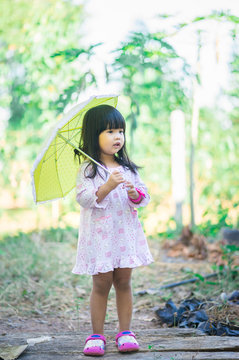 little girl with umbrella standing in the park