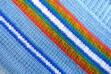 Obraz premium knitted fabric close-up soft fabric stripes natural material background for decoration blue red white yellow color geometric pattern lines crochets scarf clothes wool