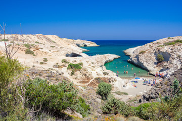 Fototapeta na wymiar Kapros, small beach between volcanic rocks with turquoise sea on Milos island, Cyclades, Greece.