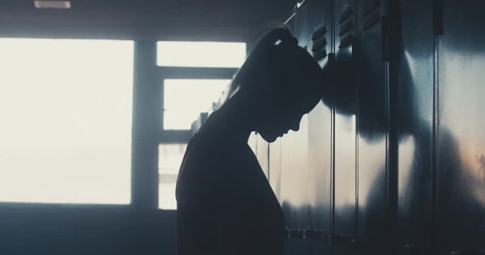 DOLLY IN Caucasian female athlete standing in a gym locker room, angry, not satisfied with her workout results. 4K UHD 60 FPS SLOW MOTION