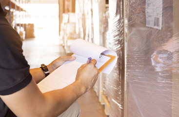 Warehouse Worker Holding Clipboard his Doing Inventory Management at Storage Warehouse. Cargo...