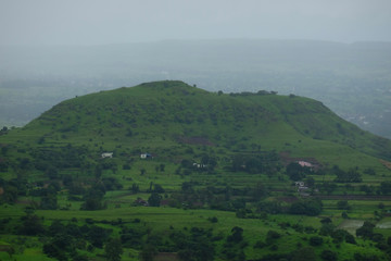 Fototapeta na wymiar Lush green monsoon nature landscape mountains, hills, farming plot, Purandar, Pune, Maharashtra, India 