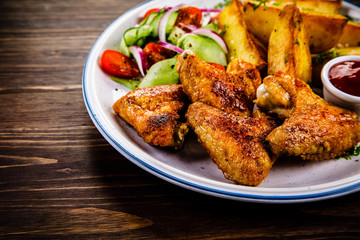 Roast chicken wings, chips and vegetables
