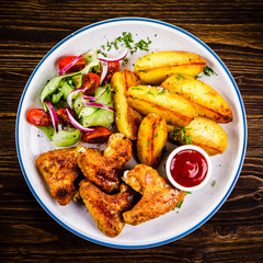 Roast chicken wings, chips and vegetables