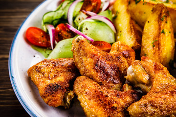 Roast chicken wings, chips and vegetables