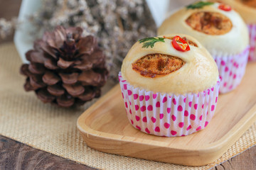 Homemade soft and sticky bun filled with dried shredded pork or pork floss and shrimp roasted chili paste on wood plate. Thai style delicious bread for snack or appetizer with sweet and spicy taste.