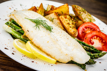 Fish dish - fried fish fillet with fried potatoes and vegetables