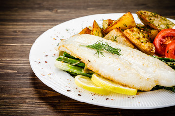 Fish dish - fried fish fillet with fried potatoes and vegetables