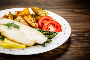 Fish dish - fried fish fillet with fried potatoes and vegetables