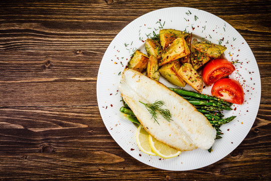 Fish dish - fried fish fillet with fried potatoes and vegetables