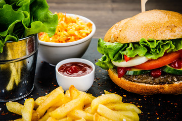 Tasty burger with chips served on stone plate 