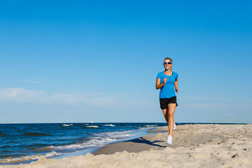 Fototapeta na wymiar Young woman running on beach 