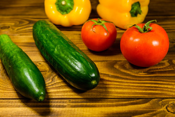 Cucumbers, tomatoes and sweet pepper on wooden table