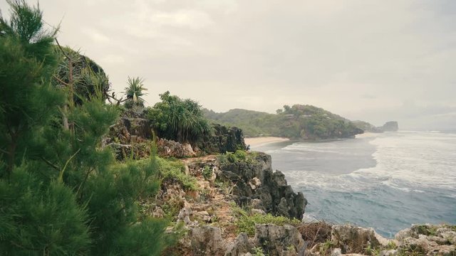 Cliffs with trees and shrubs at white sandy beach in Central Java, Indonesia