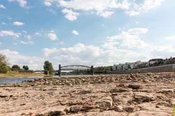 Magdeburg, Germany - August 10, 2018: View of the dry riverbed of the Elbe in Magdeburg with the lift bridge Hubbrücke in the background. Drought. Climate change.