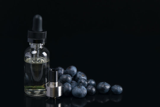 e-cigarette liquid with blueberry flavor, on black background, with berries.