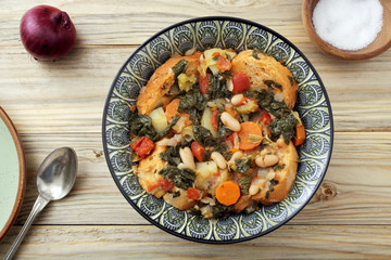 zuppa o minestra di pane con verdure su tavolo di legno