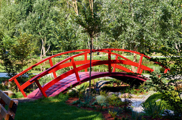 wooden red decorative bridge across the pond