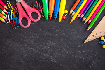 School supplies on black chalk  board background, top view. Back to school and Education concept.  Flat lay, copy-space