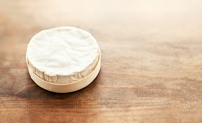 Cheese camembert on wooden desk, top view. Soft creamy cheese Brie with copy space.