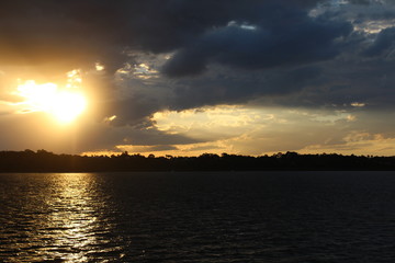 Fototapeta premium sun through clouds over water